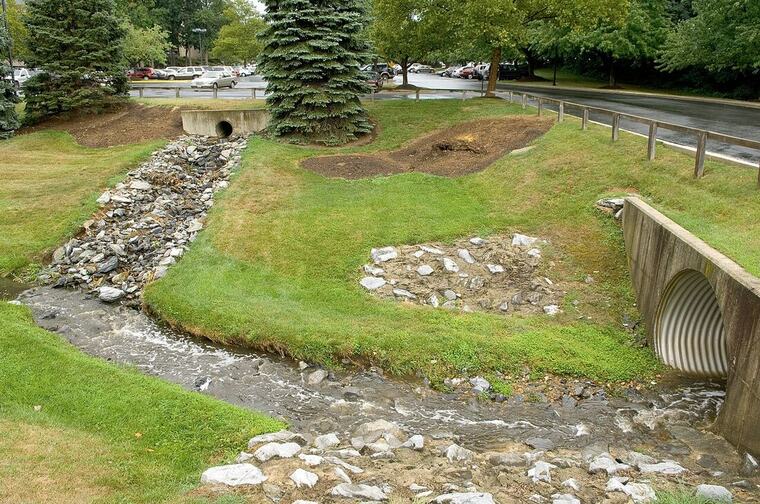 Culvert and stone-lined drainage channel carrying runoff