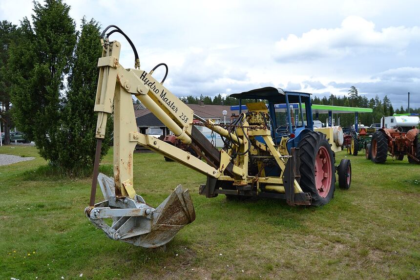 Tractor-mounted backhoe attachment used for trenching, stumps and footings