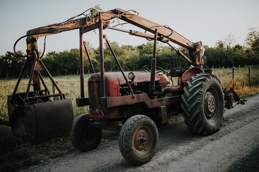 Tractor with loader and grapple for moving brush and debris