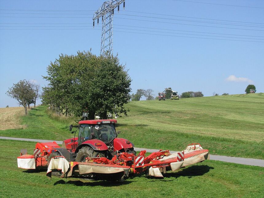Tractor and mower cutting a field in mid-Michigan